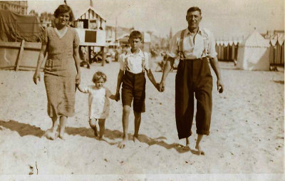 The Stone family on a beach hand in hand.