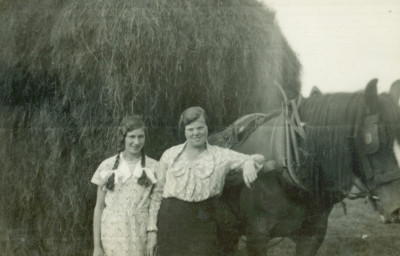 Two women  horse and hay waggon.