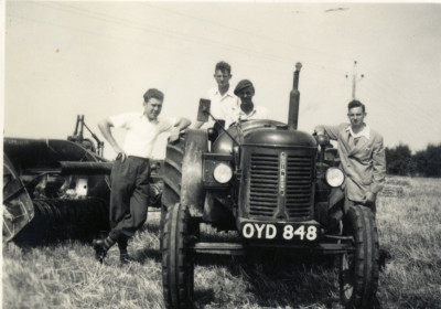 Four young men with tractor and baler.