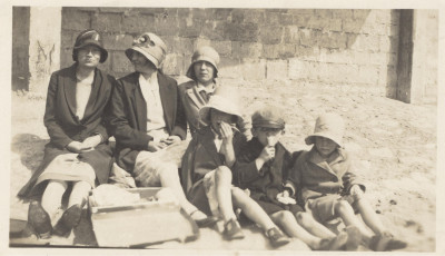 Women and children sat on beach.