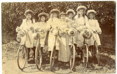 Girls  wearing bonnets  with decorated bicycles