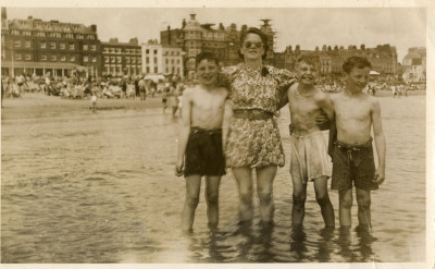 Woman with 3 boys standing in the sea at Weymouth
