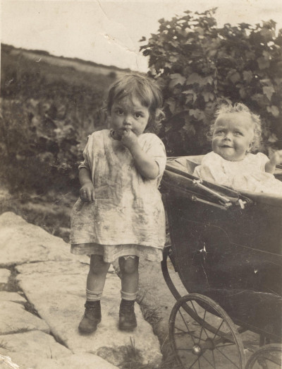 Child with a baby in a pram.
