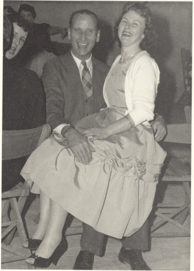 Woman on man's lap at party.