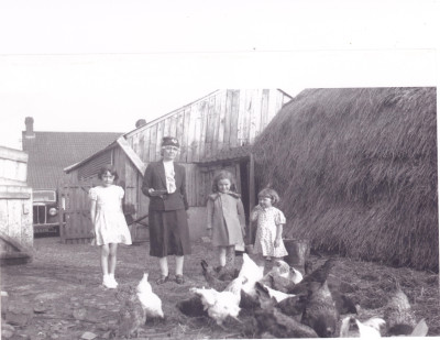 Millicent Reed, Helen Chorley feeding chickens.