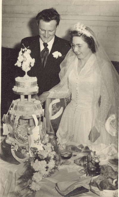 Couple cutting wedding cake.