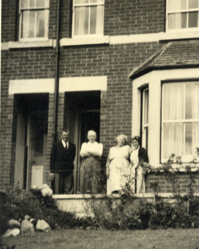 Group of adults outside brick terrace.