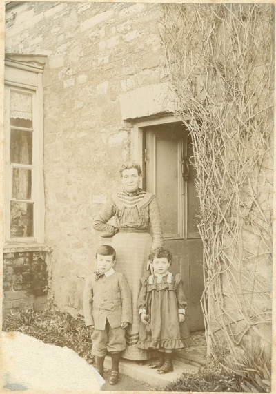 Woman and two children in doorway.