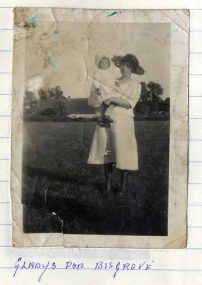 Woman wearing hat holding a baby in field