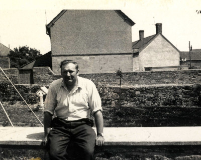 Herbert (Herbie) Lock sitting on wall