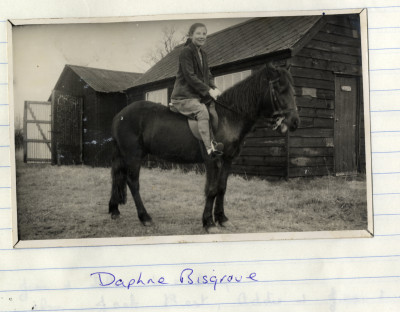 Girl on Pony next to Wooden Barn