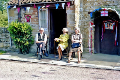 Three neighbours sitting outside Church Cottage