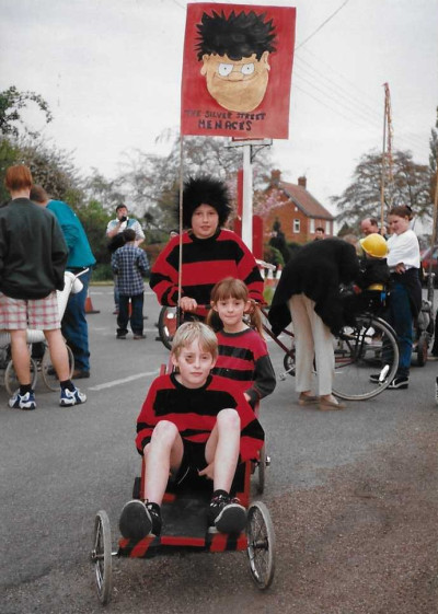 Children in fancy dress sitting on go kart