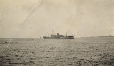 Ship with two rowing boats in water