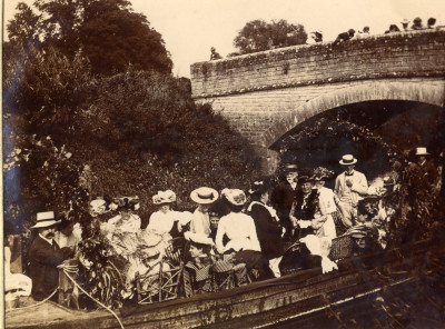 Coal barge going under Thorney Bridge on River Parrett with on lookers and  party goers