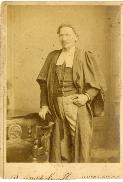 Studio photo of man in lawyers wig and gown.