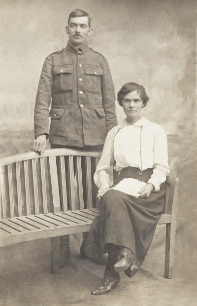 Man in uniform and woman in studio photograph.