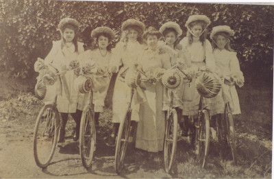 Girls in bonnets and decorated bicycles.
